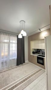 a living room with a kitchen with a window at Жк Тенгри in Shymkent