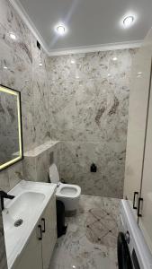 a bathroom with a sink and a toilet at Жк Тенгри in Shymkent