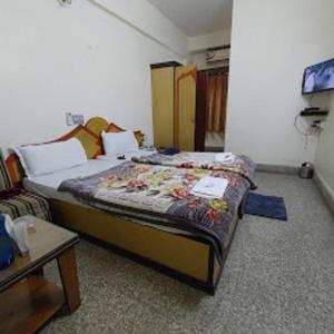 a bedroom with a bed and a tv in it at HOTEL SAPTARSHI in Bānkura +9 photos