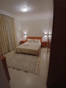 a bedroom with a bed and two lamps and a rug at Casaflor Tunis in Berges Du Lac