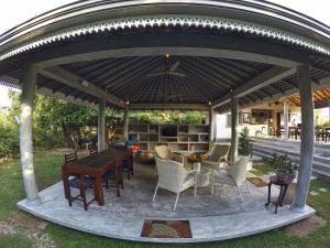 a gazebo with a table and chairs under it at The Horizon Hill Top Villa in Unawatuna