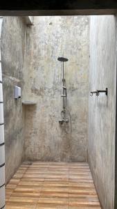 a bathroom with a shower in a concrete wall at KohMakHomeHug Resort in Ko Mak