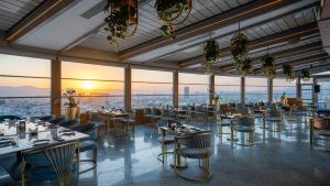 a restaurant with tables and chairs and a view of the city at Grand Millennium Sulaimani in As Sulaymānīyah