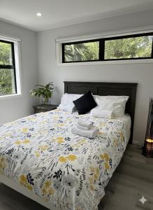 1 dormitorio con 1 cama con edredón amarillo y blanco en Modern Family Home in Tawa - Wellington, en Wellington