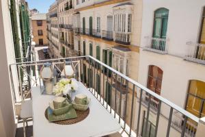 balkon ze stołem i kwiatami w obiekcie INMálaga Granada 2 w Maladze
