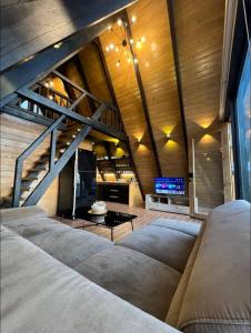 a living room with two couches and a staircase at Là Guesthouses in ‘Aynţūrah