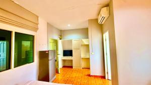 a room with a kitchen with a refrigerator in it at Cozy Bay Rawai in Phuket Town