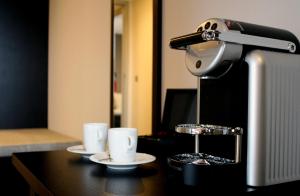 a coffee machine sitting on a table with two cups at Relais de L'Empereur in Genappe