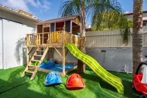 a playground with a slide and play equipment at וילת האגם - וילה מהממת בטבריה עם בריכה פרטית in Tiberias