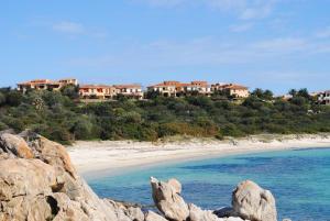 阿兰奇湾城Appartamenti Spiaggia Bianca的享有海滩和山丘上房屋的景色