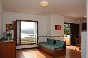 a living room with a couch and a large window at Appartamenti Spiaggia Bianca in Golfo Aranci