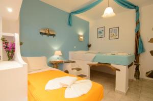 a room with two beds and a desk in it at Evi's Studios in Tholária +26 photos