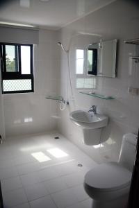 a white bathroom with a toilet and a sink at Love Door 168 in Huxi