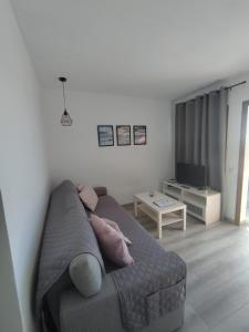a living room with a couch and a television at Flamboyán Vista Mar in Maspalomas +22 photos