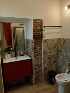 a bathroom with a sink and a mirror and a toilet at Guest House Vecchia Tranvia in Pisa