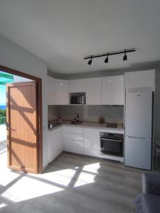 a kitchen with white cabinets and a refrigerator at Flamboyán Vista Mar in Maspalomas
