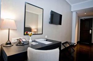 a office with a desk with a phone and a mirror at Capitol Park By Sahara Hotel in Jakarta