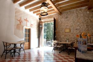 a dining room with a table and chairs and a ceiling at Petit Hotel Hostatgeria La Victoria in Alcudia