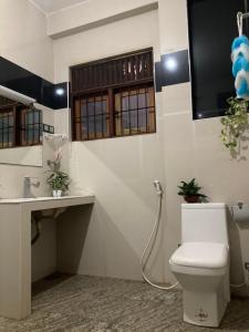 a bathroom with a toilet and a sink at OHASA Home stay in Gampaha +6 photos