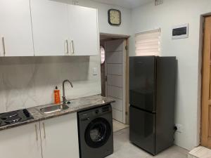 a kitchen with a refrigerator and a washing machine at GRACE self-catering apartments in Goodwood +5 photos