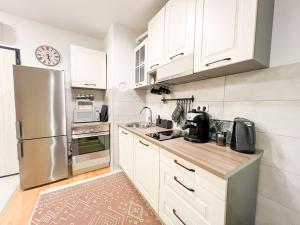 a kitchen with white cabinets and a stainless steel refrigerator at DAMI in Tuzla