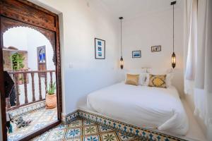 a bedroom with a bed and a mirror at Riad Dar Irdide in Essaouira