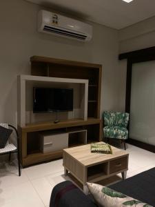 a living room with a flat screen tv and a table at Hawana Salalah Tourism in Ma‘mūrah