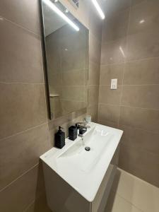 a bathroom with a white sink and a mirror at Hawana Salalah Tourism in Ma‘mūrah +9 photos