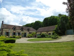 a house with a driveway and a grass yard at Le Clos des Cordeliers in Sézanne