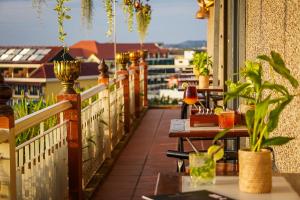 een patio met tafels en planten op een balkon bij Bronam Residence & Spa in Phumĭ Ta Phŭl