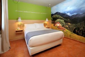 a bedroom with a large bed with a painting on the wall at PirineosNature Apartments in Plan