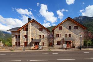 un gran edificio de piedra en el lateral de una calle en PirineosNature Apartments, en Plan
