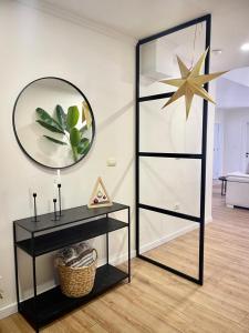 a black console table with a mirror and a star on the wall at Gjirokastra Design Apartments in Gjirokastër
