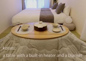 ein Tisch mit eingebautem Heiler und eine Decke in einem Schlafzimmer in der Unterkunft reたたみのお宿 in Chikusachō
