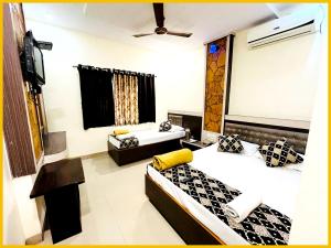 a hotel room with two beds and a tv at Hotel S B Residency Near Shri Sai Baba Temple - Fully Air conditioned Room - Free Wifi And parking Available - Best Premium Hotel In Shirdi in Shirdi +21 photos