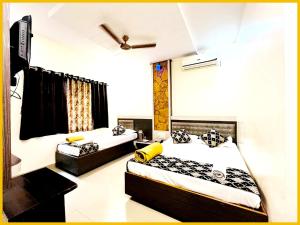 a bedroom with two beds and a tv in it at Hotel S B Residency Near Shri Sai Baba Temple - Fully Air conditioned Room - Free Wifi And parking Available - Best Premium Hotel In Shirdi in Shirdi