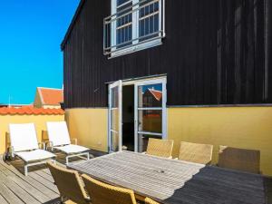 een terras met een tafel en stoelen en een gebouw bij 6 person holiday home in Skagen in Skagen +19 foto's
