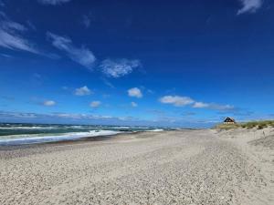 een zandstrand met een huis in de verte bij 6 person holiday home in Skagen in Skagen