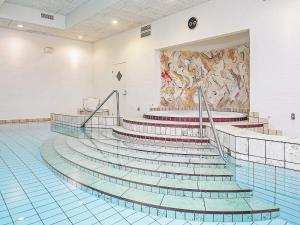 een zwembad met trap en een schilderij aan de muur bij 6 person holiday home in Skagen in Skagen