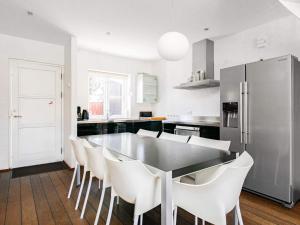 een keuken met een eettafel en witte stoelen bij 6 person holiday home in Skagen in Skagen