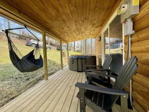 a porch with two chairs and a hammock on it at Alone At Last - New LUX - WiFi - Hot Tub in High Falls