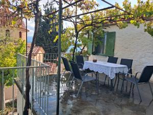 a white table and chairs on a patio at πλατανα Αστρους Αρκαδίας χωριατικο σπίτι για φυση και ηρεμία in Rounaíika