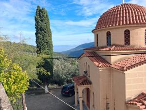 a church with a car parked in a parking lot at πλατανα Αστρους Αρκαδίας χωριατικο σπίτι για φυση και ηρεμία in Rounaíika