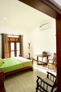 a bedroom with a bed and a table and a chair at Sun Side Villa in Ginimellagaha West
