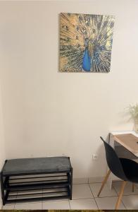 ein Bild eines Pfaus hängt an einer Wand in der Unterkunft studio proche Orly et villes 91 in La Ville-du-Bois