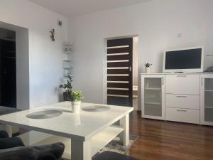 a living room with a white table and a tv at Agroturystyka Pod Dzwonnicą - Babia Góra in Zubrzyca Dolna