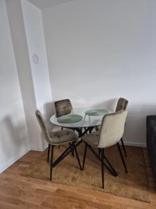 a dining room table with two chairs and a glass table at Hari Apartmani Oaza in Tuzla +2 photos