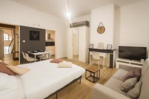 a bedroom with a white bed and a living room at Toison d'Or Apartment in Brussels