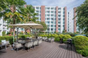 a patio with a table and chairs and an umbrella at The One Chiang Mai 214 - Family Suite 2BR 2bath, Pool View near Central Festival in Chiang Mai