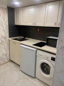 eine Küche mit Waschmaschine und Spüle in der Unterkunft Апартаменты Promenade Burabay 45 b кв 73 а in Borovoye